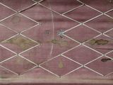 a picture of a rusted wall with a chain link fence