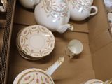 a lot of tea pots and cups sitting in a box