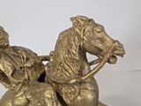 a statue of a man riding a horse with a woman on it