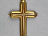 gros plan d'une croix en or sur une surface blanche