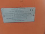 une caisse orange sur laquelle est posée une étiquette, posée dans un entrepôt