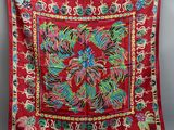 a red cloth with colorful designs hanging on a clothes line