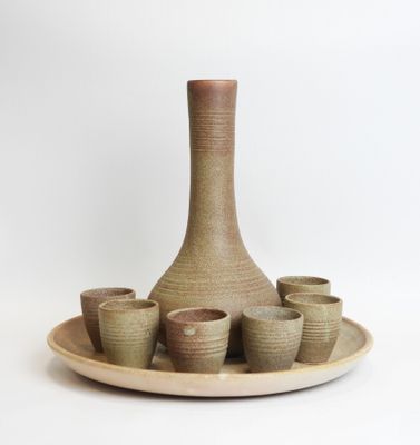 a picture of a vase and cups on a plate