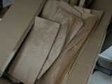 a box full of brown paper bags sitting on the floor