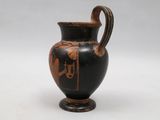 a black vase with a red design on it