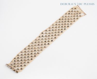 bracelet composé de perles en or et en argent sur fond blanc