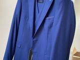 the blue suit is hanging on a hanger in front of a mirror