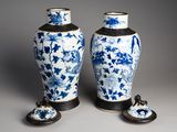 pair of blue and white vases with flowers and leaves on them