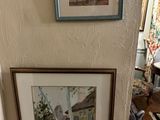two framed pictures on the wall of a room