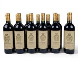six bottles of wine are lined up in a row on a white surface