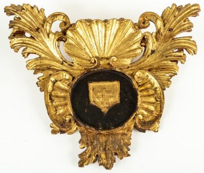 une broche dorée et noire ornée d'un bouclier