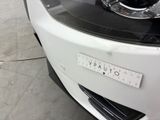 a close up of a white car with a sticker on the front of it