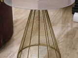 a table that has a glass top and a gold base
