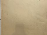 an old piece of paper with a sticker on it sitting on a table