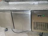 a counter with a sink and a refrigerator in it