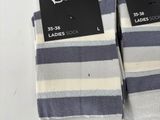 two pairs of white and blue striped socks with black tags on them