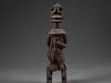 une figurine en bois représentant un homme à la tête et aux bras volumineux