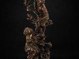 a bronze statue of a boy and girl sitting on a tree branch