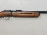 un fusil posé sur une table près d'un mur