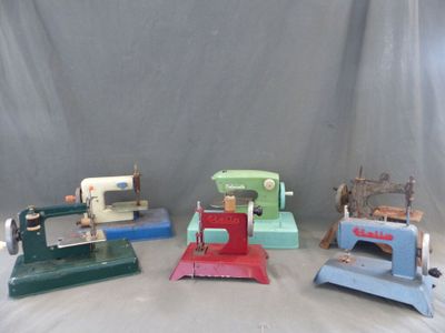 quatre types différents de machines à coudre posées sur une table