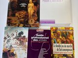 plusieurs livres posés sur une table, sur laquelle se trouve un ordinateur portable