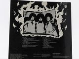 a black and white photo of a picture of three women in front of a fire