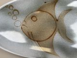 a plate with a fish design on it on a table