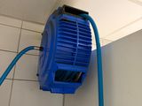 a blue blower attached to a wall in a bathroom