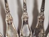 five silver spoons that are sitting on a table