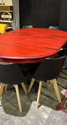 a red table with black chairs in a room