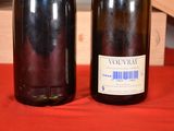 two bottles of wine sitting on a red cloth