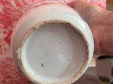 a person holding a cup that is sitting on a table