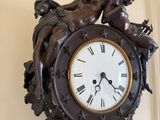 a clock on the wall that has a statue on it