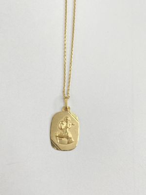 a gold necklace with an image of a woman on it