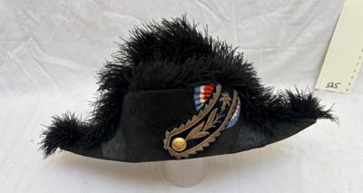 un chapeau noir orné d'une plume sur le dessus