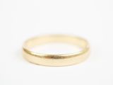 gros plan d'une bague en or sur une surface blanche