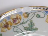 a plate with flowers painted on it sitting on a table
