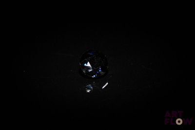 a close up of a diamond in the dark with a black background
