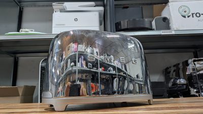 a toaster that is sitting on a table in front of a shelf