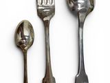 three spoons and a fork on a white surface