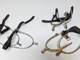 trois paires de lunettes et une paire de ciseaux posés sur une table
