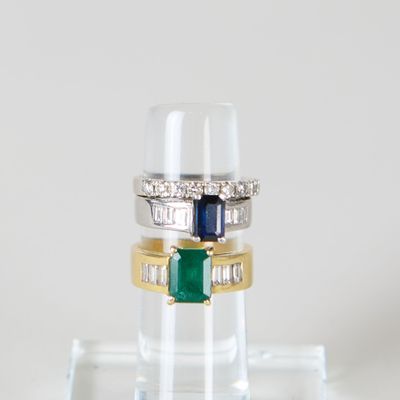 trois pierres de couleurs différentes sont empilées les unes sur les autres sur un socle transparent
