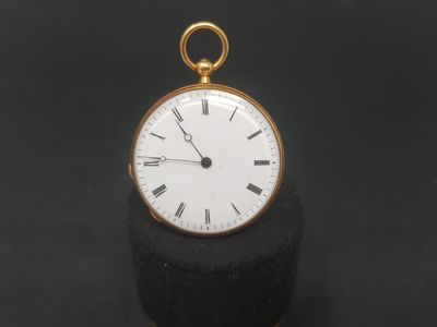an antique gold pocket watch with roman numerals on the face