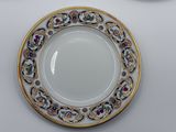 a white plate with a gold rim and a blue and white plate with a gold rim