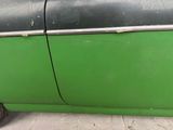 a close up of a green car with a black door