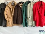 many coats hanging on a rack on a wall