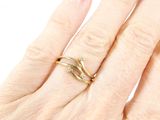 a woman ' s hand with a gold ring on it