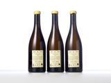 three bottles of wine sit side by side on a white surface