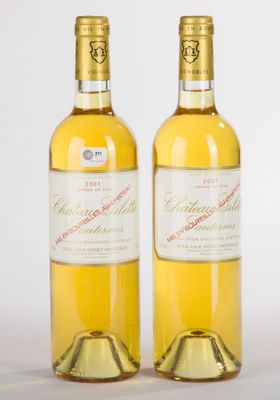 deux bouteilles de vin blanc posées l'une à côté de l'autre sur une surface blanche