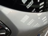 a close up of a car ' s rear end with a reflection of a building in the rear window